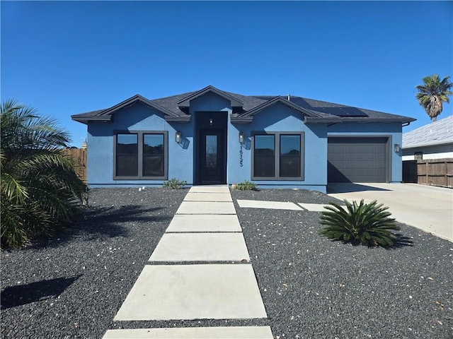 16125 Seagrape St, Corpus Christi, TX 78418 - view of front of house with stucco siding, concrete driveway, roof mounted solar panels, and an attached garage