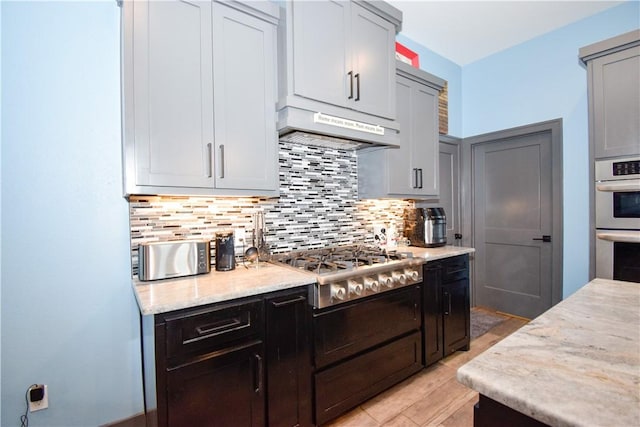 16125 Seagrape St, Corpus Christi, TX 78418 - kitchen featuring appliances with stainless steel finishes, under cabinet range hood, backsplash, and light stone counters