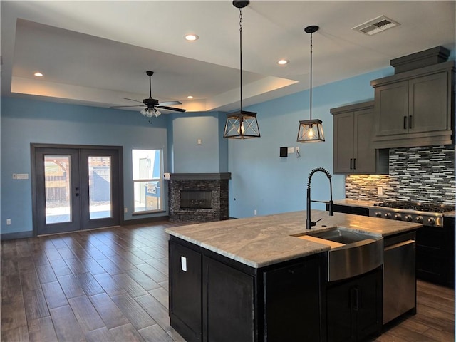 16125 Seagrape St, Corpus Christi, TX 78418 - kitchen with a tray ceiling, tasteful backsplash, a ceiling fan, dark wood-style floors, and a kitchen island with sink