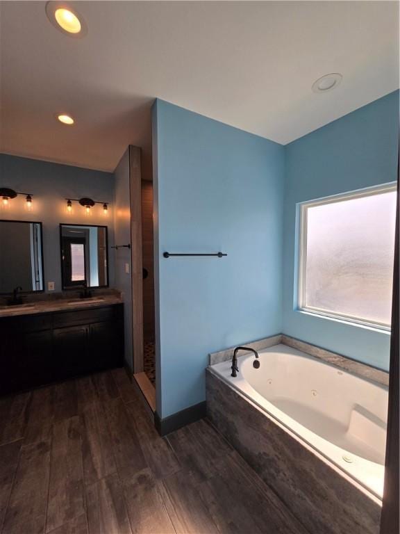 16125 Seagrape St, Corpus Christi, TX 78418 - bathroom featuring double vanity, a whirlpool tub, and wood finished floors