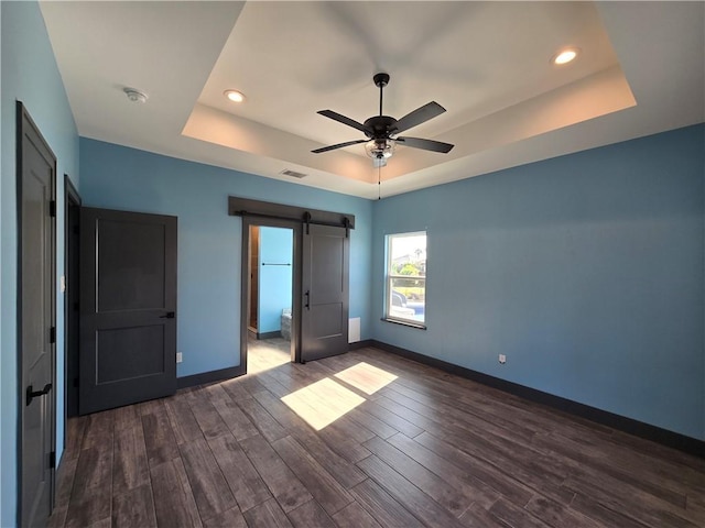 16125 Seagrape St, Corpus Christi, TX 78418 - unfurnished bedroom featuring a raised ceiling, a barn door, dark wood-type flooring, recessed lighting, and a ceiling fan