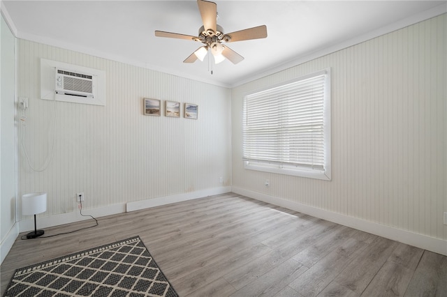 spare room featuring ceiling fan, light hardwood / wood-style floors, an AC wall unit, and ornamental molding