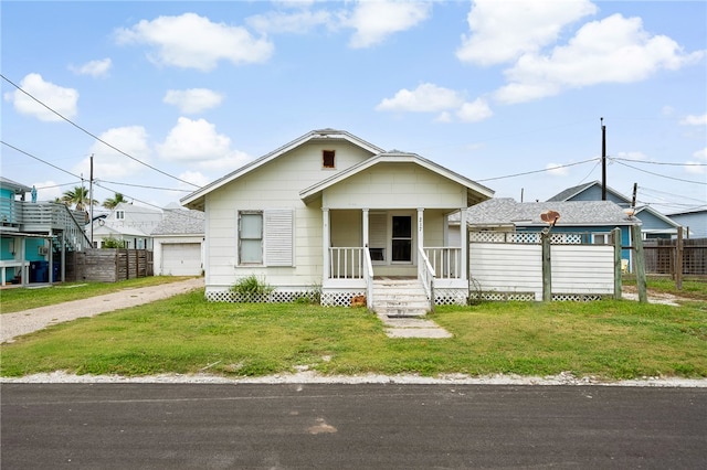 bungalow with a front yard, a porch, a garage, and an outdoor structure