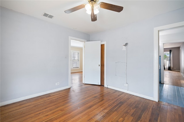 unfurnished room with ceiling fan and dark wood-type flooring