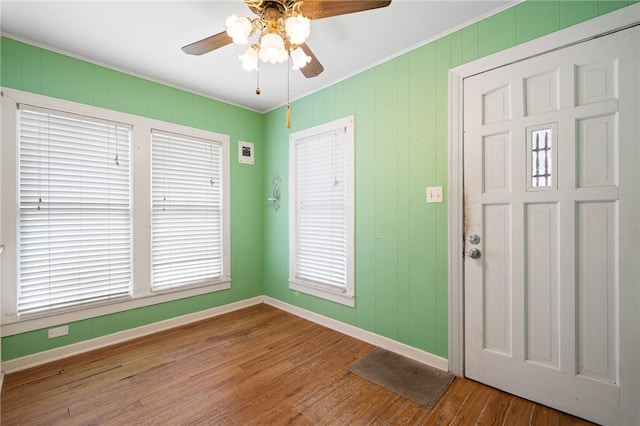 foyer featuring hardwood / wood-style flooring, ceiling fan, and crown molding