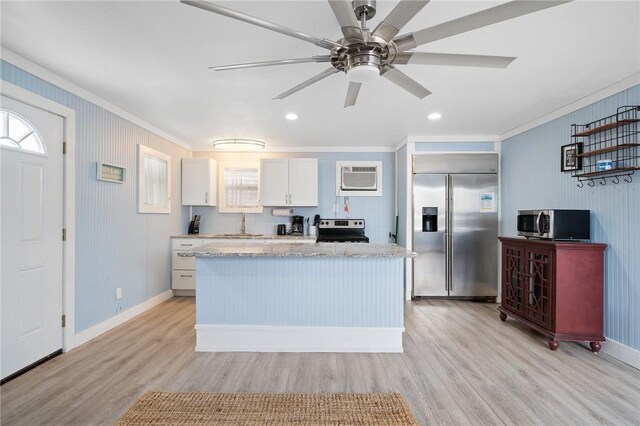 217 E Brundrett Ave, Port Aransas, TX 78373 - kitchen with appliances with stainless steel finishes, crown molding, light wood-style flooring, a wall mounted air conditioner, and a center island