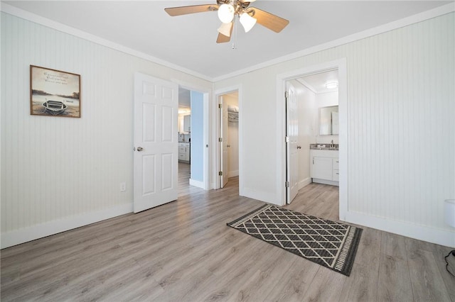 217 E Brundrett Ave, Port Aransas, TX 78373 - unfurnished bedroom featuring ornamental molding, baseboards, attic access, wood finished floors, and a spacious closet