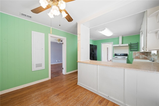 kitchen with black refrigerator with ice dispenser, extractor fan, sink, electric range, and white cabinets