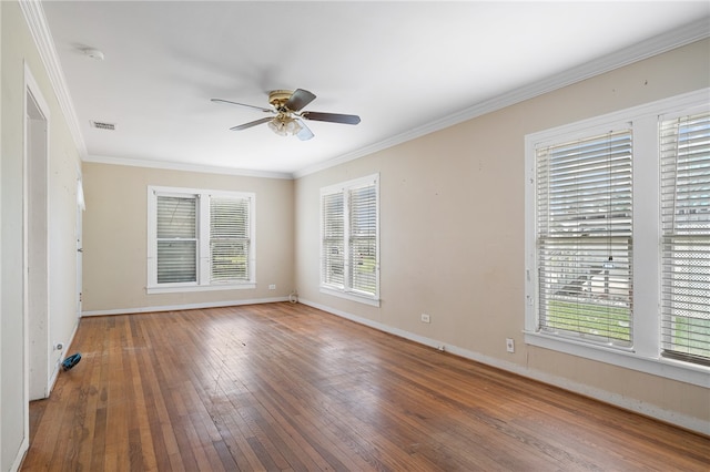 empty room featuring hardwood / wood-style flooring, crown molding, and a wealth of natural light