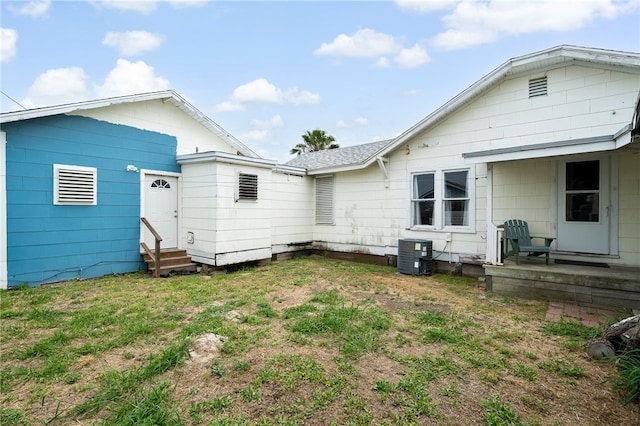 back of house featuring central air condition unit and a yard