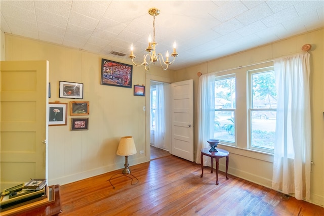 interior space with wood-type flooring and a notable chandelier