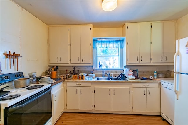 kitchen with white cabinets, light wood-type flooring, sink, and white appliances