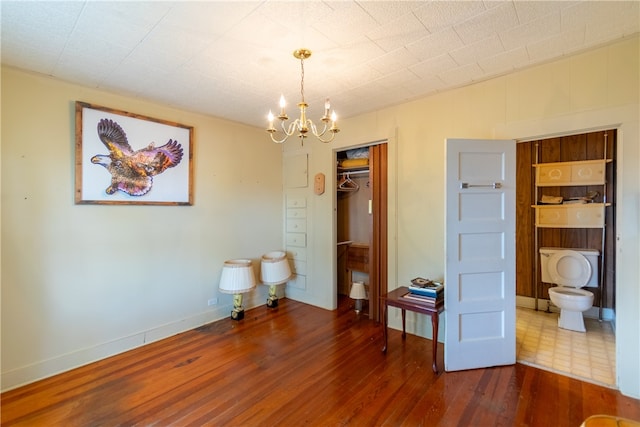 bedroom with hardwood / wood-style floors, a closet, and an inviting chandelier