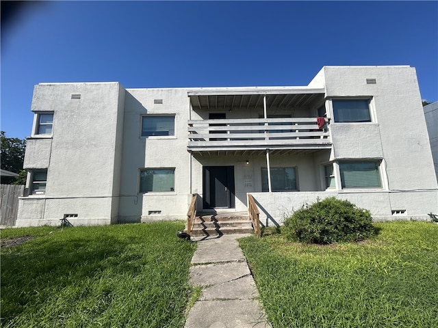 view of front of house featuring a front yard and a balcony