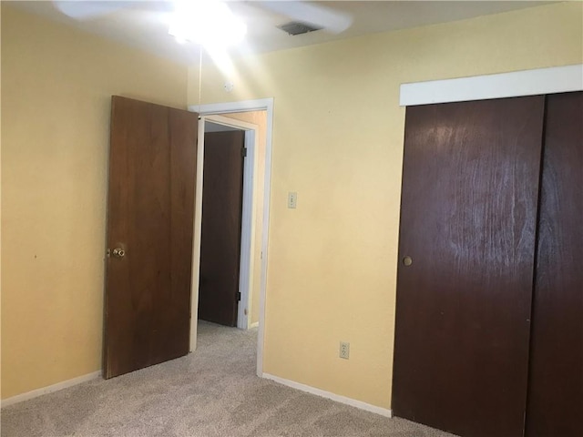 unfurnished bedroom featuring carpet, a closet, visible vents, and baseboards