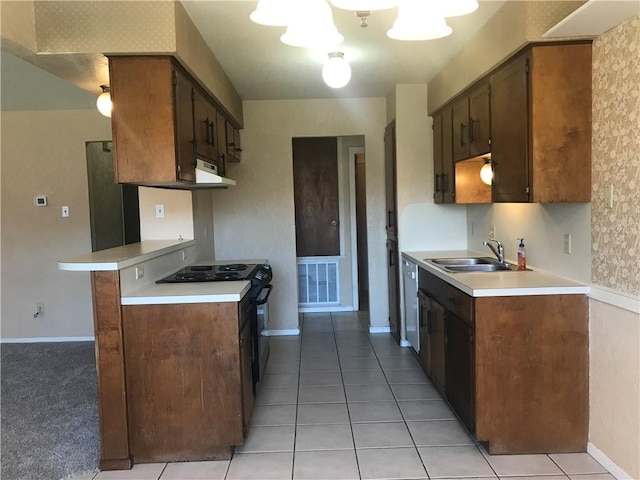 kitchen with black range with electric cooktop, visible vents, light countertops, and a sink