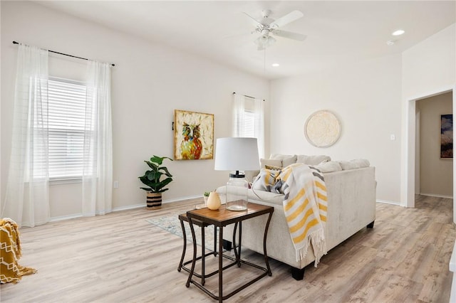 living room featuring recessed lighting, light wood-type flooring, and baseboards