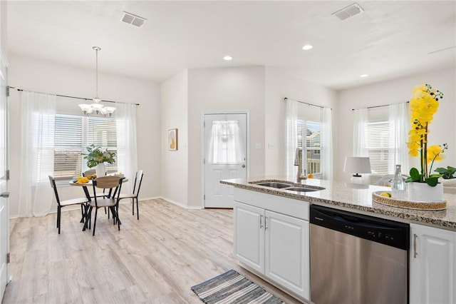 kitchen featuring light stone countertops, visible vents, light wood finished floors, a sink, and dishwasher