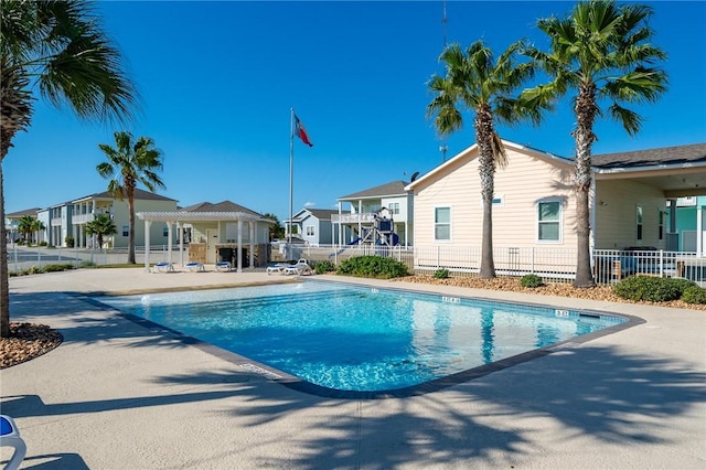 community pool with a residential view, a patio, and fence