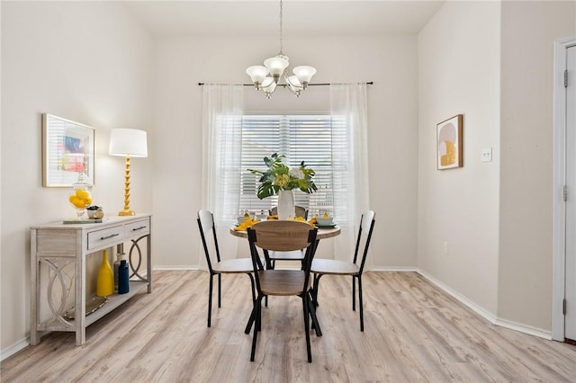 dining room with baseboards, light wood-type flooring, and an inviting chandelier