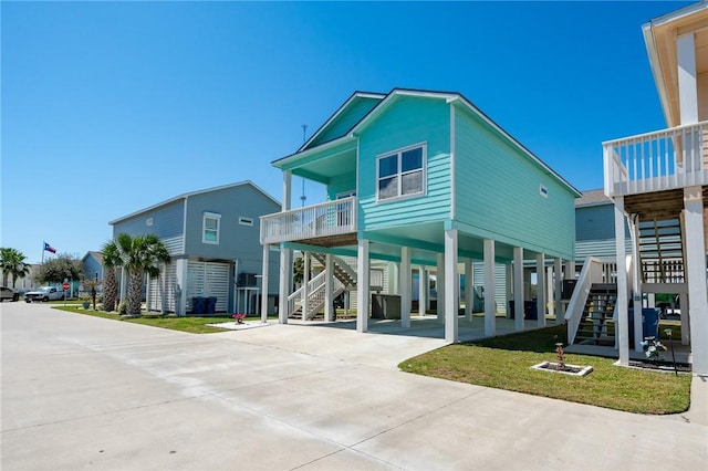 view of building exterior featuring a carport, stairway, and concrete driveway