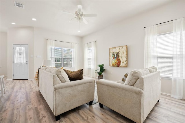 living room with light wood-type flooring, visible vents, a ceiling fan, recessed lighting, and baseboards