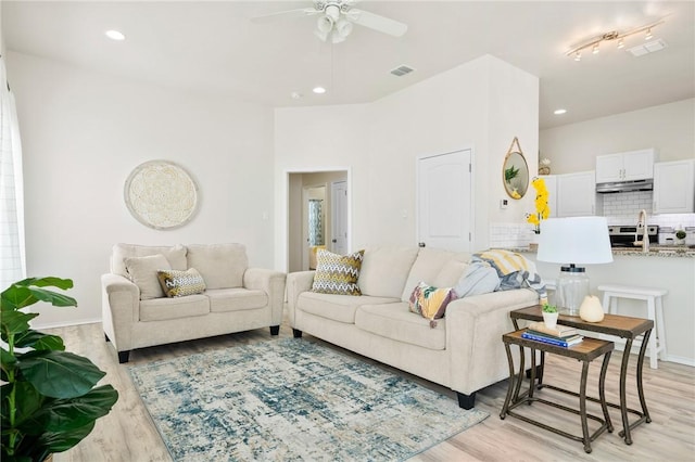 living room with ceiling fan, visible vents, light wood-style flooring, and recessed lighting