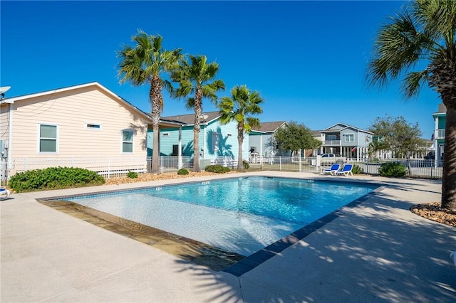 pool with a patio and fence