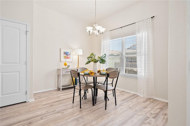 dining space featuring a notable chandelier, light wood-style flooring, and baseboards