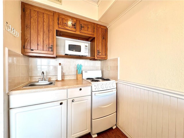 3938 Surfside Unit 3233, Corpus Christi, TX 78402 - kitchen featuring white appliances, light countertops, tasteful backsplash, a wainscoted wall, and dark wood-type flooring