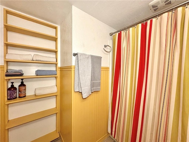 3938 Surfside Unit 3233, Corpus Christi, TX 78402 - full bath featuring a wainscoted wall and a shower with shower curtain