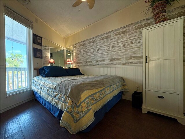 3938 Surfside Unit 3233, Corpus Christi, TX 78402 - bedroom with a wainscoted wall, lofted ceiling, wood finished floors, and ceiling fan