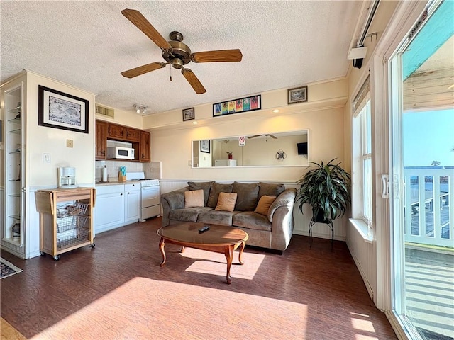 3938 Surfside Unit 3233, Corpus Christi, TX 78402 - living room featuring dark wood-style flooring, a textured ceiling, a ceiling fan, and healthy amount of natural light