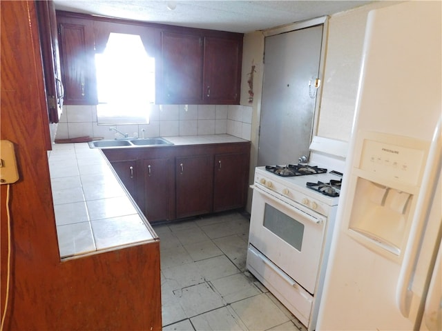 kitchen with tile countertops, sink, white appliances, and backsplash