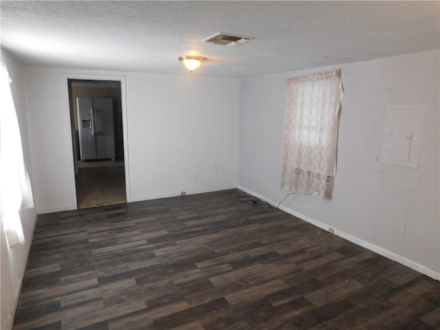 unfurnished room featuring electric panel, a textured ceiling, and dark hardwood / wood-style floors