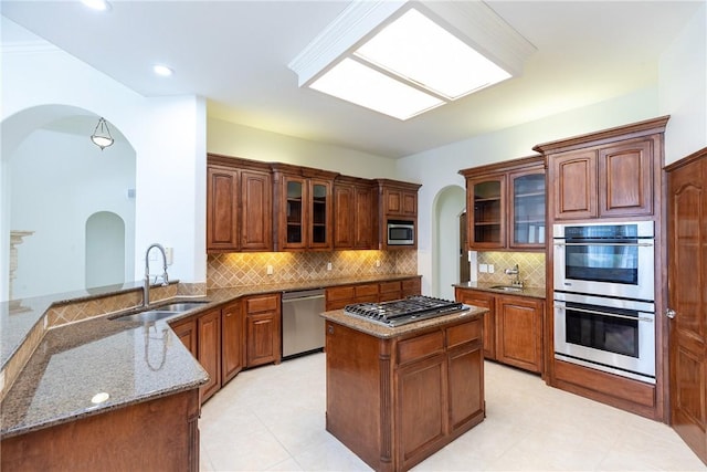 4 E Bar Le Doc Dr, Corpus Christi, TX 78414 - kitchen featuring appliances with stainless steel finishes, arched walkways, stone countertops, glass insert cabinets, and tasteful backsplash