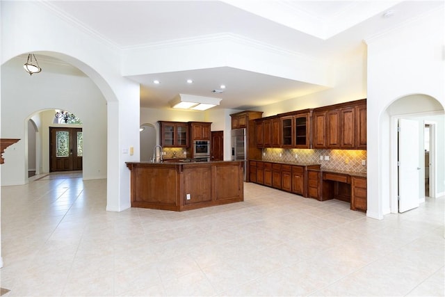4 E Bar Le Doc Dr, Corpus Christi, TX 78414 - kitchen featuring a peninsula, arched walkways, glass insert cabinets, dark countertops, and a breakfast bar area