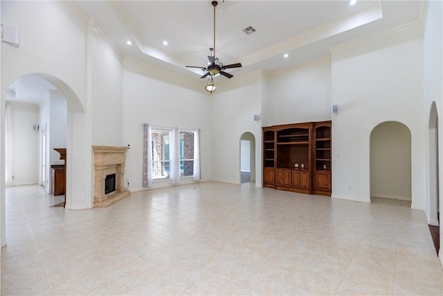 4 E Bar Le Doc Dr, Corpus Christi, TX 78414 - unfurnished living room with a towering ceiling, a ceiling fan, arched walkways, a raised ceiling, and ornamental molding