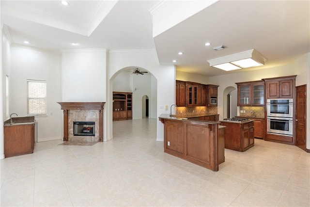4 E Bar Le Doc Dr, Corpus Christi, TX 78414 - kitchen with stainless steel appliances, open floor plan, arched walkways, glass insert cabinets, and ornamental molding