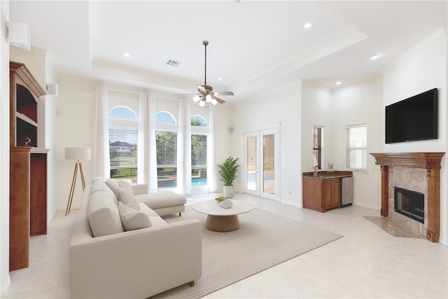 4 E Bar Le Doc Dr, Corpus Christi, TX 78414 - living room with a tray ceiling, a high end fireplace, recessed lighting, light tile patterned floors, and a ceiling fan