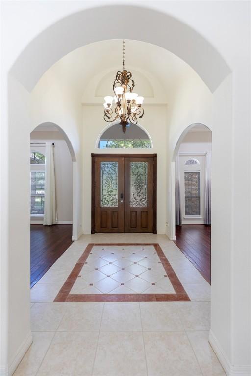 4 E Bar Le Doc Dr, Corpus Christi, TX 78414 - entryway featuring a chandelier, a towering ceiling, arched walkways, and inlaid floor details