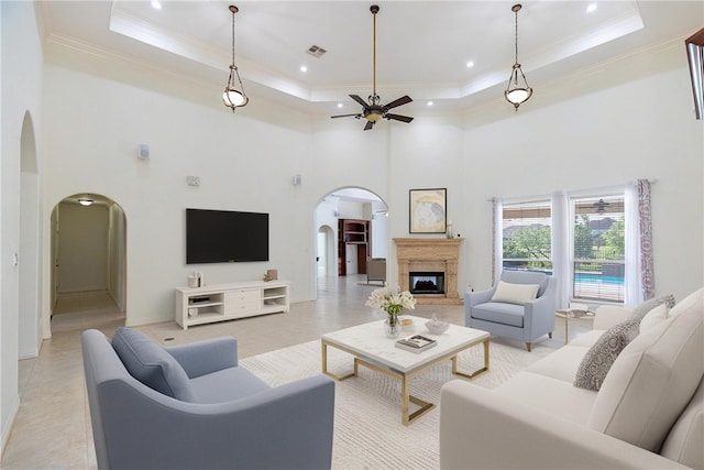 4 E Bar Le Doc Dr, Corpus Christi, TX 78414 - living room featuring arched walkways, ceiling fan, a tray ceiling, a towering ceiling, and ornamental molding