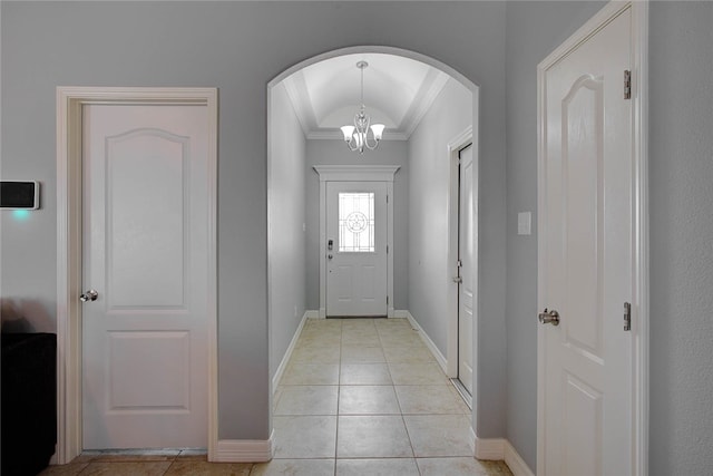 doorway to outside with a chandelier, light tile patterned floors, and crown molding