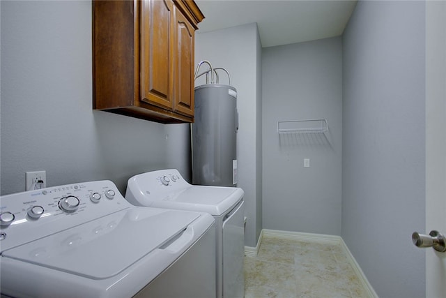 laundry area with cabinets, washing machine and dryer, and water heater