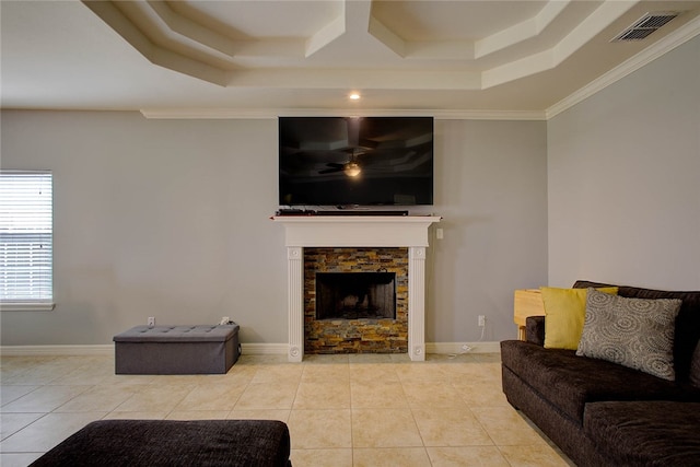 tiled living room featuring a stone fireplace and crown molding