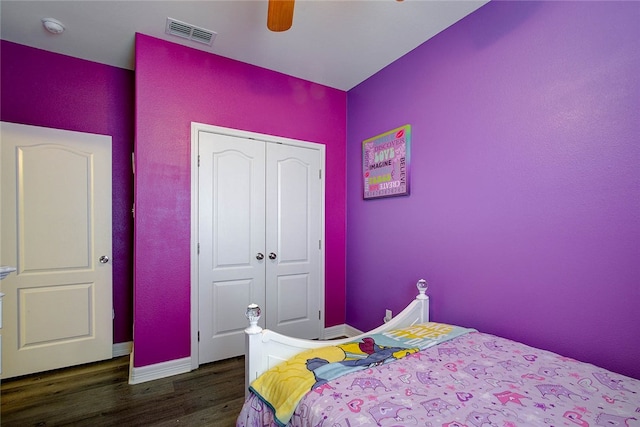 bedroom featuring dark wood-type flooring, a closet, and ceiling fan