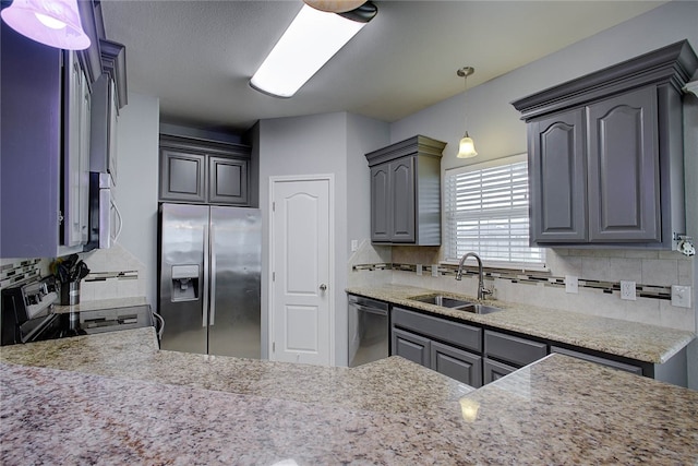 kitchen with stainless steel appliances, gray cabinets, sink, and decorative backsplash