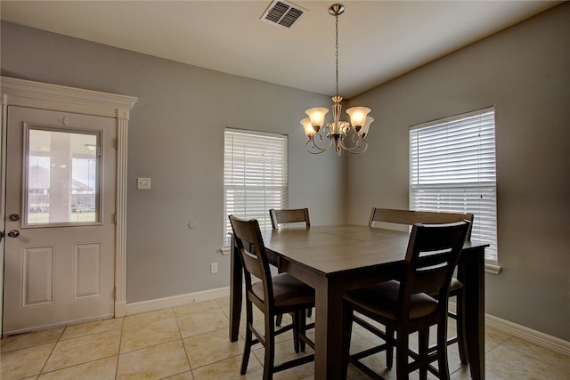 tiled dining area featuring a wealth of natural light and an inviting chandelier