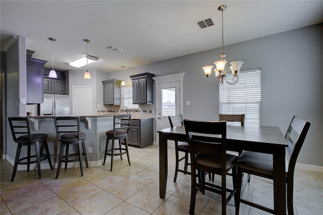 tiled dining room featuring a chandelier and sink