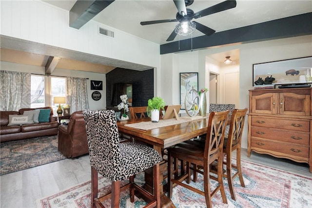 dining space with beamed ceiling, ceiling fan, and light hardwood / wood-style flooring